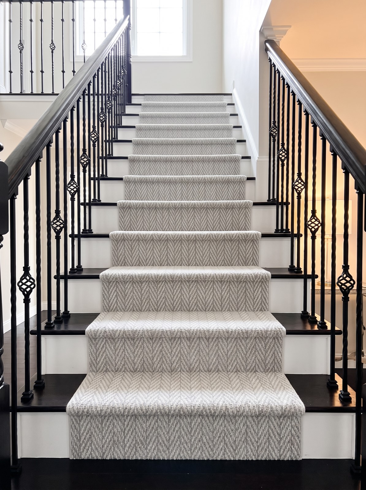 Staircase with a gray herringbone carpet runner installed by Red Carpet