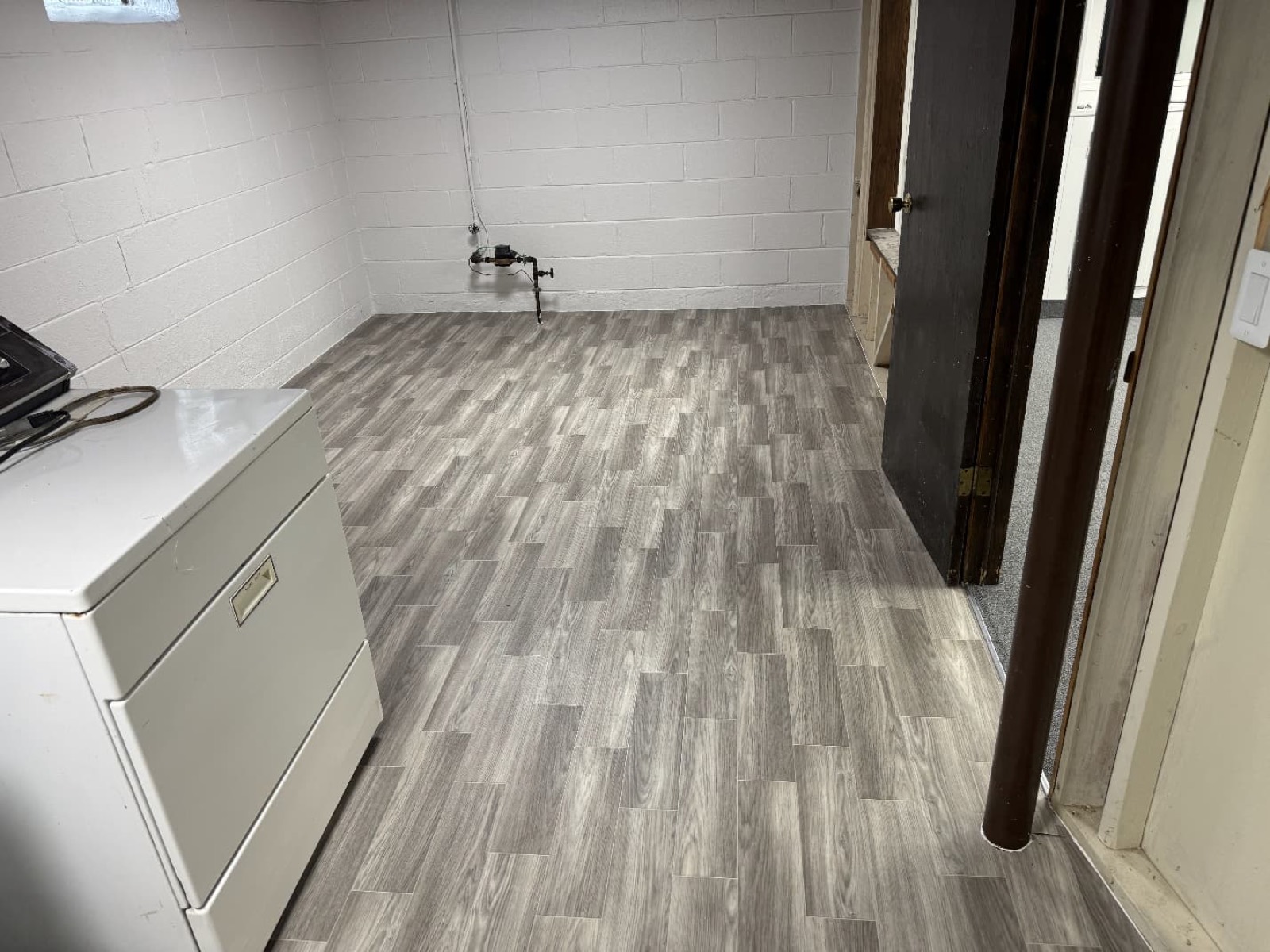 Gray luxury vinyl plank flooring in a finished basement
