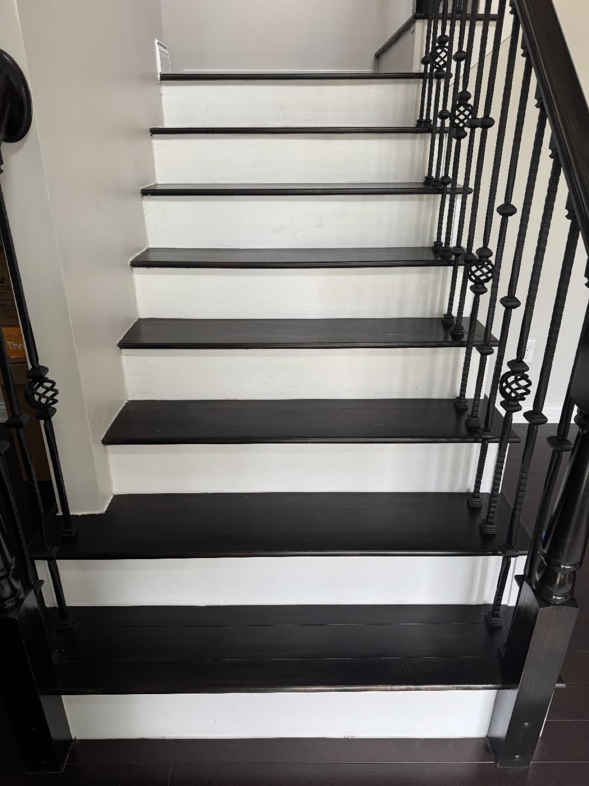 Black-tread and white-riser staircase with iron balusters