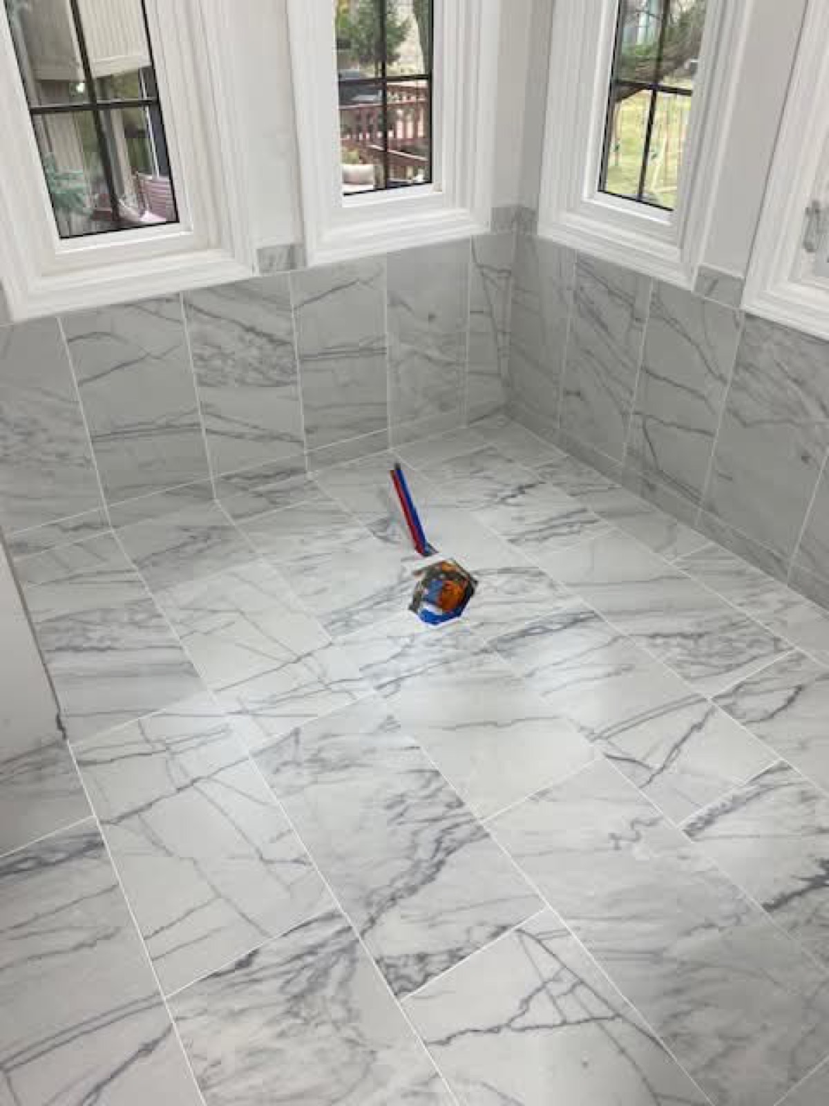 Calacatta marble-look tile floor by a window